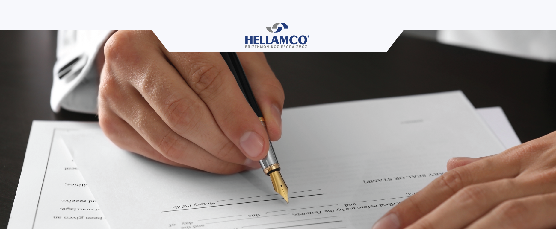 Man's hands holding a pen as he signs a job application form.